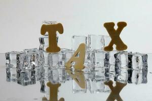 Tax alphabet ice cube freeze cool on white background photo