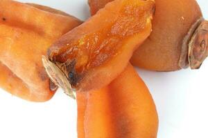 dried permission fruit on white background photo