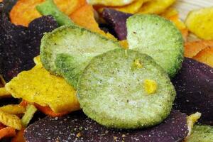 Healthy vegetable chips yellow sweet potato purple sweet potato carrot green radish green beans and shiitake mushrooms photo