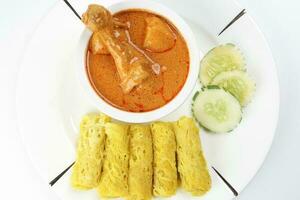 Traditional Malay snack food Roti Jala served with curry chicken with potato on white ceramic plate and bowl photo