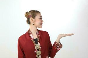 Asian woman traditional red maroon kebaya sharong on white background showing display hand palm photo