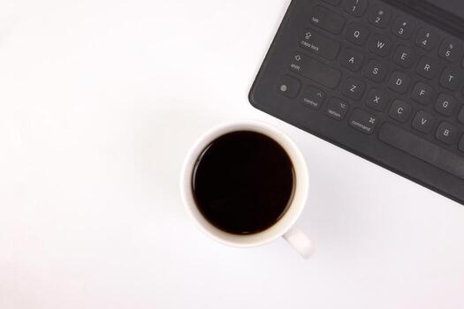 negro computadora teclado café taza bolígrafo en blanco antecedentes parte superior ver Copiar texto espacio foto
