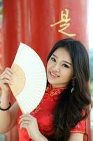 Young south east asian Chinese man woman traditional costume Chinese new year greeting outdoors at temple photo