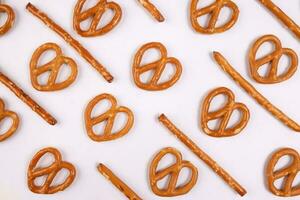 Pretzel cracker sticks laid in rows design angle straight on what background photo