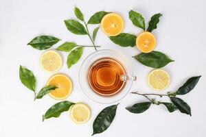 different types of fresh raw green tea leaf flower bud lemon orange slice transparent glass teacup saucer liquid tea on white background top view photo