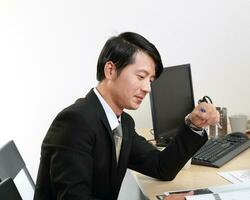 Young Asian man woman wearing business office suit chair table computer white background photo