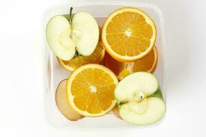 mix green red apple orange whole fruit cut slice half in plastic container on white background photo