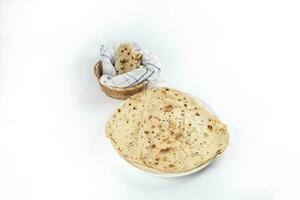 Paper thin rumali roit wheat chapati bread on white plate best served with dal tadka makhana photo