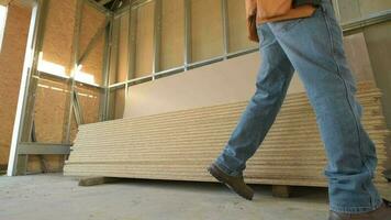 Kaukasisch bouw arbeider in beweging multiplex planken. video