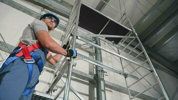 Adult Male Construction Worker Looking Down And Around While Standing High On Scaffold Inside Of Building Under Construction. video