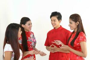 South East Asian young Malay Chinese Indian man woman wearing traditional chinse cheongsam dress on white background shop exchange gift orange greetings share racial unity harmony hand fan photo