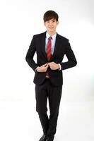 Young mart handsome Asian man business office wearing suit tie on white background walk forward photo