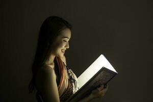 Asian woman opening mystic book box magical light dark background photo