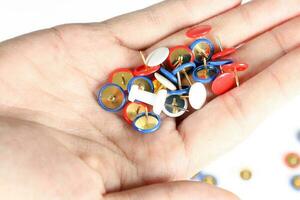 Colorful board pin on palm of hand photo