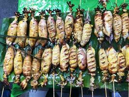 Charcoal grilled stuffed Squid Calamari cattle fish on green banana leaf photo