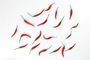 Fresh birds eye red chilli scattered top view on white background photo