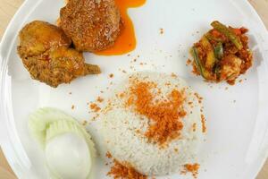 Nasi Lemak Rice cooked with coconut milk floss with curry chicken sambal vegetable boiled egg cucumber slice photo