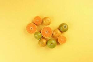 small yellow green mandarin orange whole slice on yellow background copy space for text photo