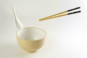 Empty oriental Japanese Chinese soup bowl spoon chopstick elevated flying in air off white photo