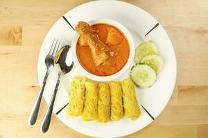 Traditional Malay snack food Roti Jala served with curry chicken with potato on white ceramic plate and bowl photo