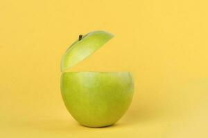 Healthy Green Cut Apple floating top slice juice drink idea concept on yellow background photo