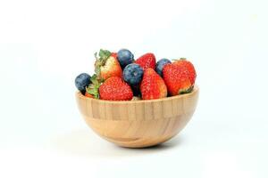 Strawberry blueberry in wooden bowl on white background photo