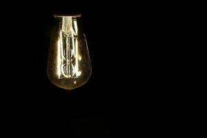 ligero bulbo tungsteno LED en apagado parpadeo en negro antecedentes foto