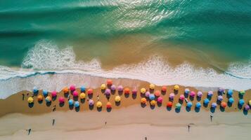 parte superior ver de arenoso playa con turquesa mar agua y vistoso azul sombrillas, aéreo zumbido disparo. generativo ai. foto