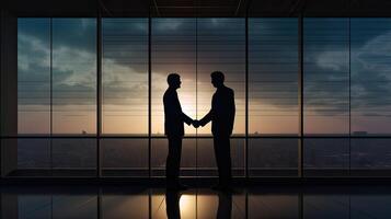 silhouettes two businessmen handshake in cooperation agreement concept at office and successful business partner. business man shaking hands to seal a deal with his partner. . photo