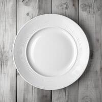 An empty plate on a white wooden table. Top view of white ceramic plate on white wooden. . photo