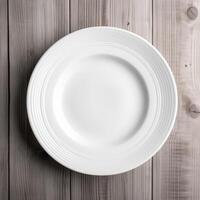 An empty plate on a white wooden table. Top view of white ceramic plate on white wooden. . photo