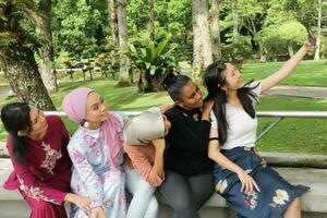 group of five woman Malay Chinese Indian Asian Malaysian outdoor green park lake nature selfie smartphone camera self portrait photo