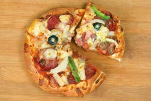 Pizza beef chicken peperoni cheese chilli capsicum onion olive on wooden board photo