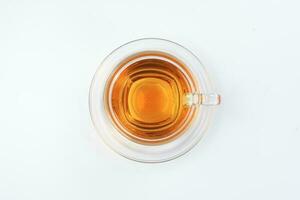 Clear licker tea in a transparent glass cup saucer on white background photo