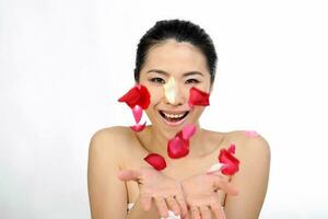 Young beautiful Southeast Asian woman beauty fashion makeup light grey white background flower patellas flying palm of hand photo