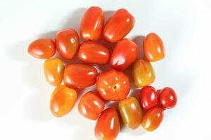 Fresh ripe small shiny red tomato on white background photo