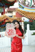 Young south east asian Chinese man woman traditional costume Chinese new year greeting outdoors at temple photo