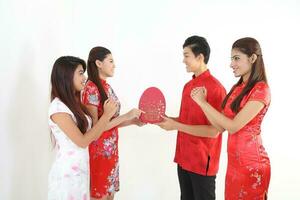 South East Asian young Malay Chinese Indian man woman wearing traditional chinse cheongsam dress on white background shop exchange gift orange greetings share racial unity harmony hand fan photo