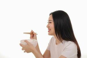 hermosa joven sur este asiático mujer participación chino vacío palillo sopa cuchara cuenco utensilio fingir interino posando ver comer gusto alimentar oferta satisfacción sabroso blanco antecedentes contento foto