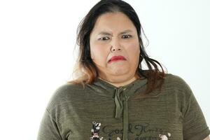 Young plus size south east asian woman pose face expression emotion on white background disgusted photo