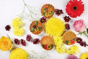 Colorful flower decorated moon cake Chinese mid autumn festival daisy chrysanthemum mum rose baby breath flower red yellow pink purple violet on white background photo