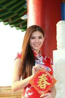 joven sur este asiático chino hombre mujer tradicional disfraz chino nuevo año saludo al aire libre a templo foto