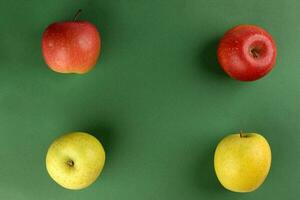 Red yellow green apple on green colour paper background copy space for text photo