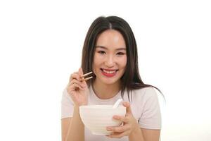 Beautiful young south east Asian woman holding chinese empty chopstick soup spoon bowl utensil pretend acting posing see eat taste feed offer satisfaction yummy white background happy photo