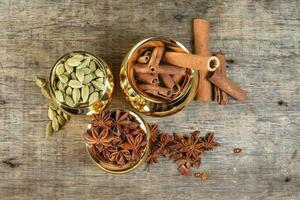 mix spice in golden metal pot on rustic wood photo