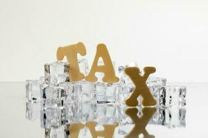 Tax alphabet ice cube freeze cool on white background photo