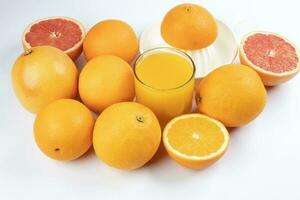 Fresh orange juice in glass on white yellow background photo