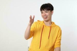 Young good looking Asian chinese malay man pose face body expression mode emotion on white background laugh at someone hand in air photo