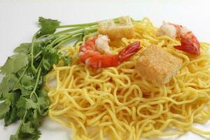 Fresh yellow egg noodle prawn tofu coriander leaf on whit background photo