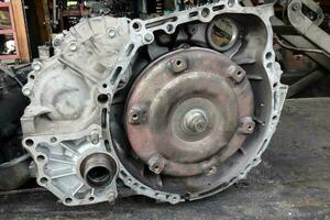 Old dirty used broken Auto transmission gearbox on workshop floor for damaged repair photo